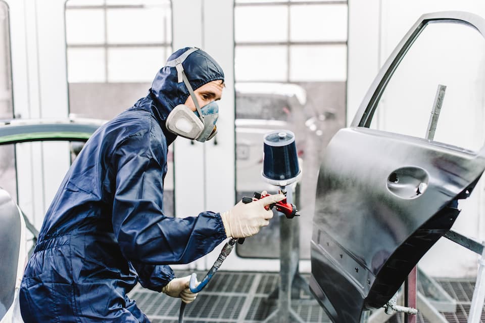 Lackierer in der Lackierkabine